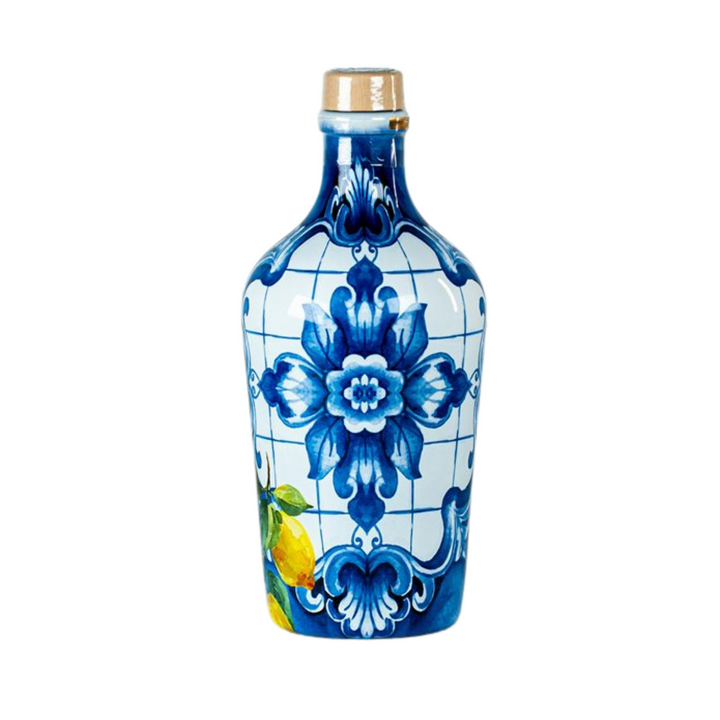 A decorative ceramic bottle with a blue and white floral pattern reminiscent of traditional Delftware, featuring a gold-colored metal cap, set against a plain white background.