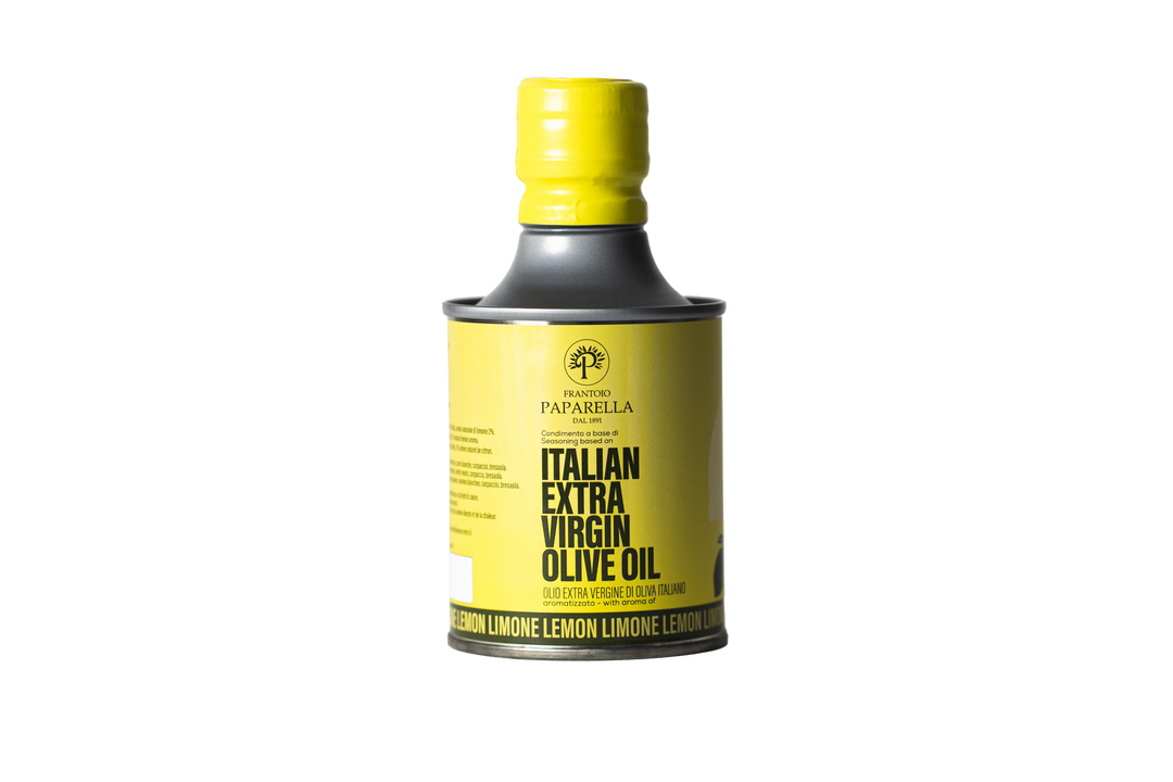 Bottle of lemon infused Italian extra virgin olive oil with a yellow cap on a white background