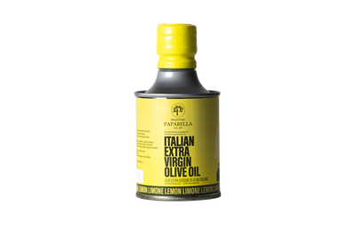 Bottle of lemon infused Italian extra virgin olive oil with a yellow cap on a white background