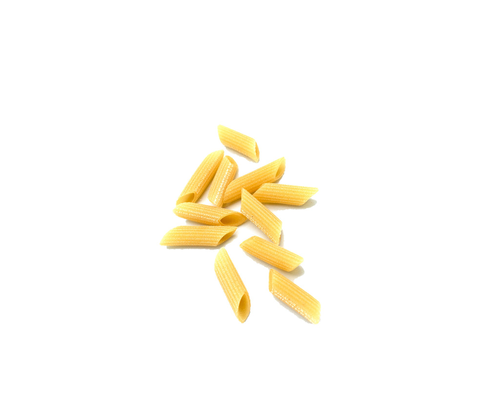 Several pieces of uncooked penne pasta arranged in a small cluster on a plain white background.