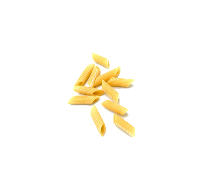 Several pieces of uncooked penne pasta arranged in a small cluster on a plain white background.